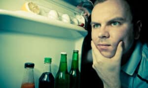 man looking in refrigerator