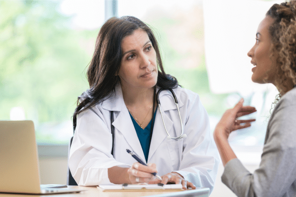 A healthcare professional discussing GLP-1 and weight loss treatment options with a patient.