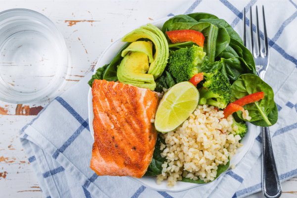 Balanced meal with salmon, vegetables, avocado, and whole grains to support blood sugar control